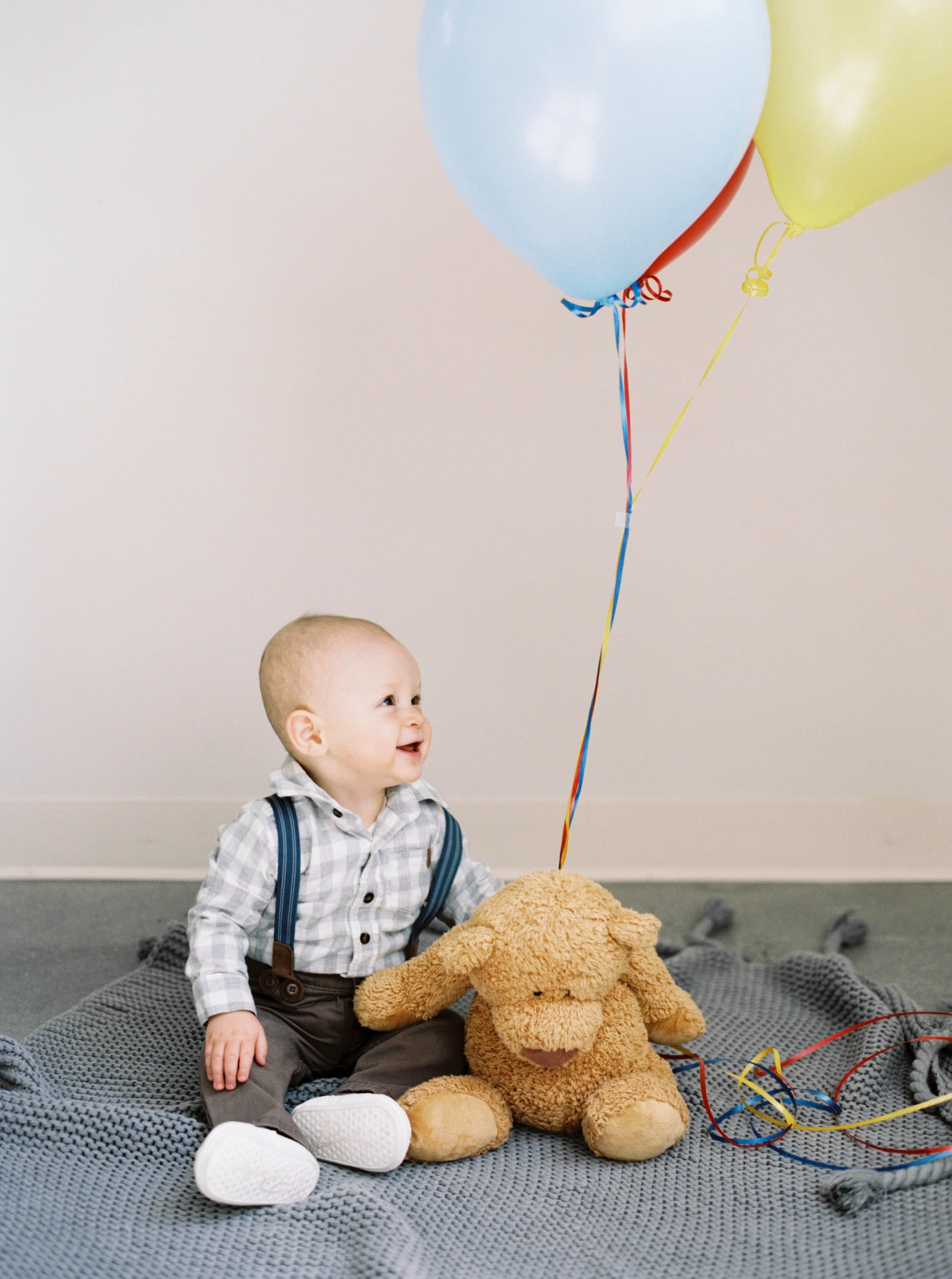 Baby holding balloons for a photograph in Acton, MA