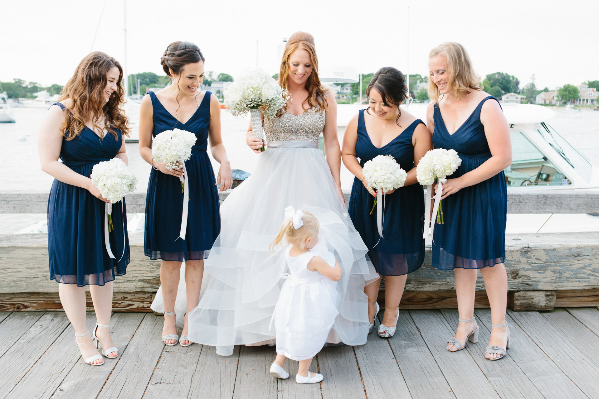 Bride and bridesmaids playing with flower girl
