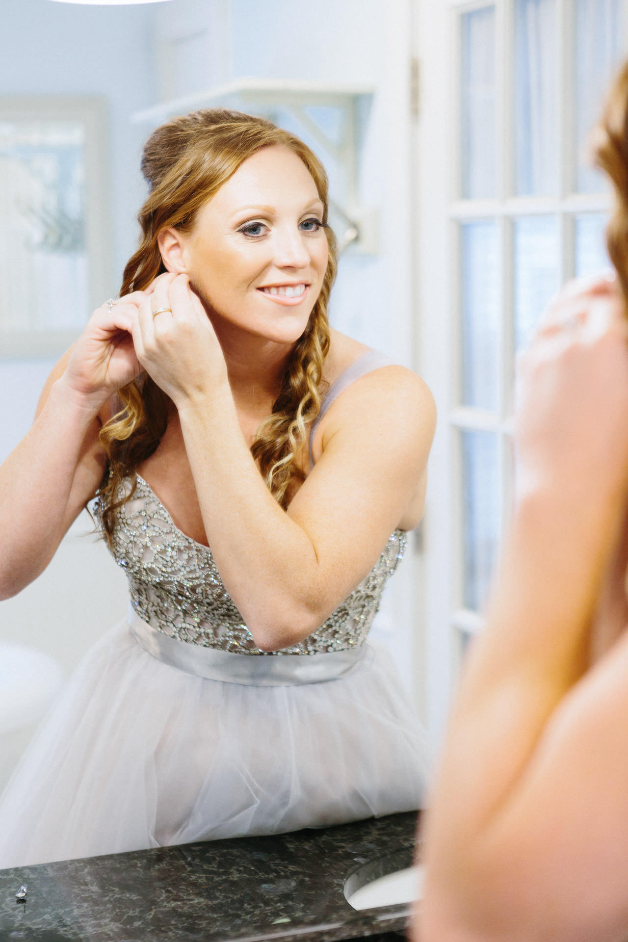 Bride putting on her earrings for her Boston wedding