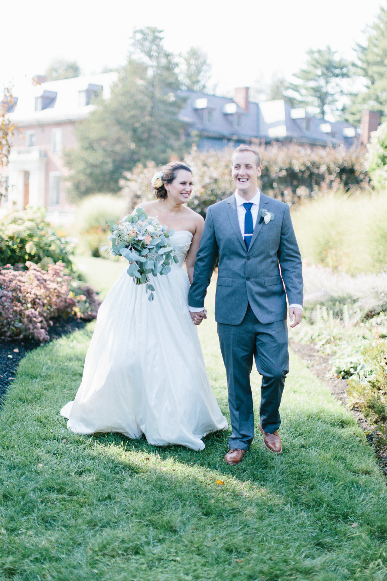 Bride and Groom smiling and walking in a garden