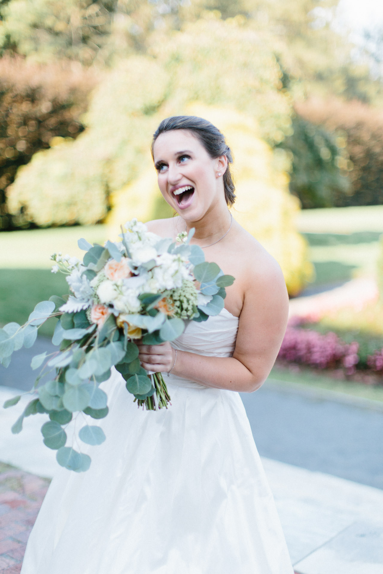 Bride laughing holding her flower bouquet