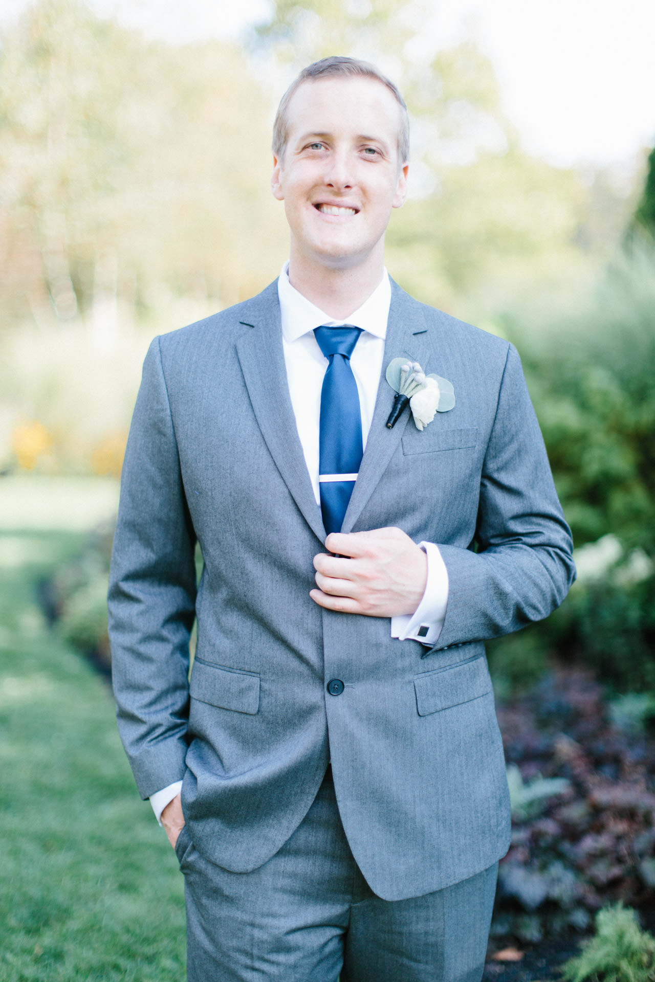 Groom posing for a photograph during his wedding at The Gardens at Elm Bank in Wellesley, MA