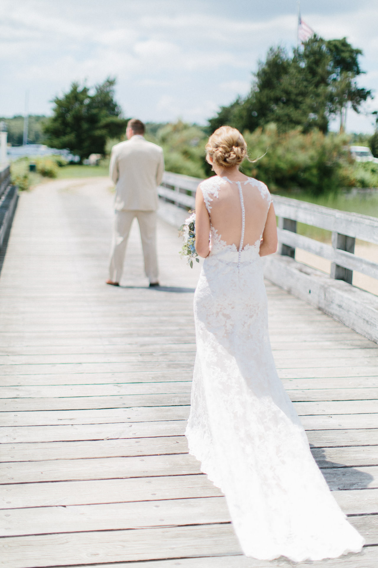 Bride and Groom posing for their first look photograph on a bridge during their Cape Cod wedding at The Coonamessett Inn in Falmouth, MA 