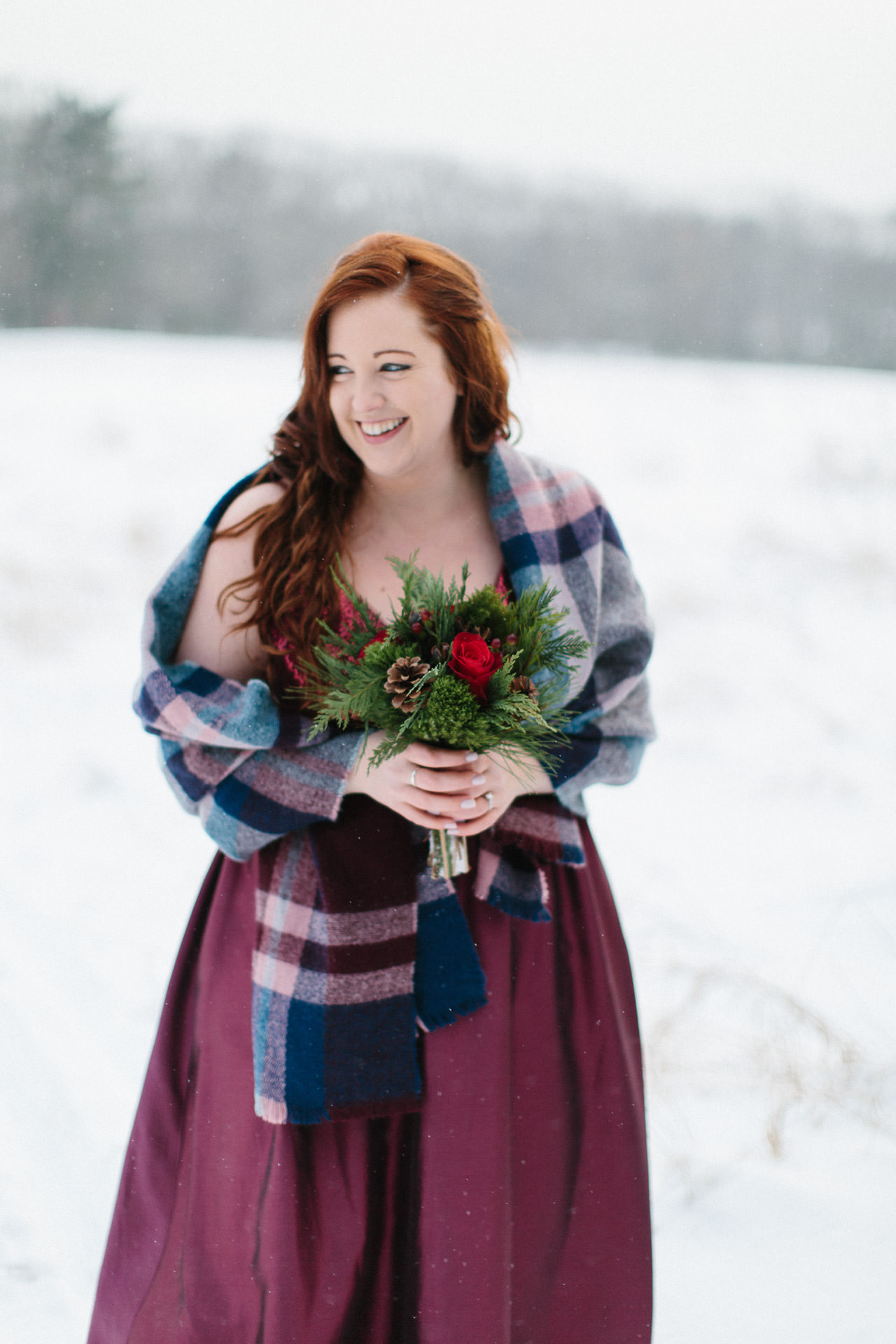 Bride in red wedding gown holding bouquet and smiling