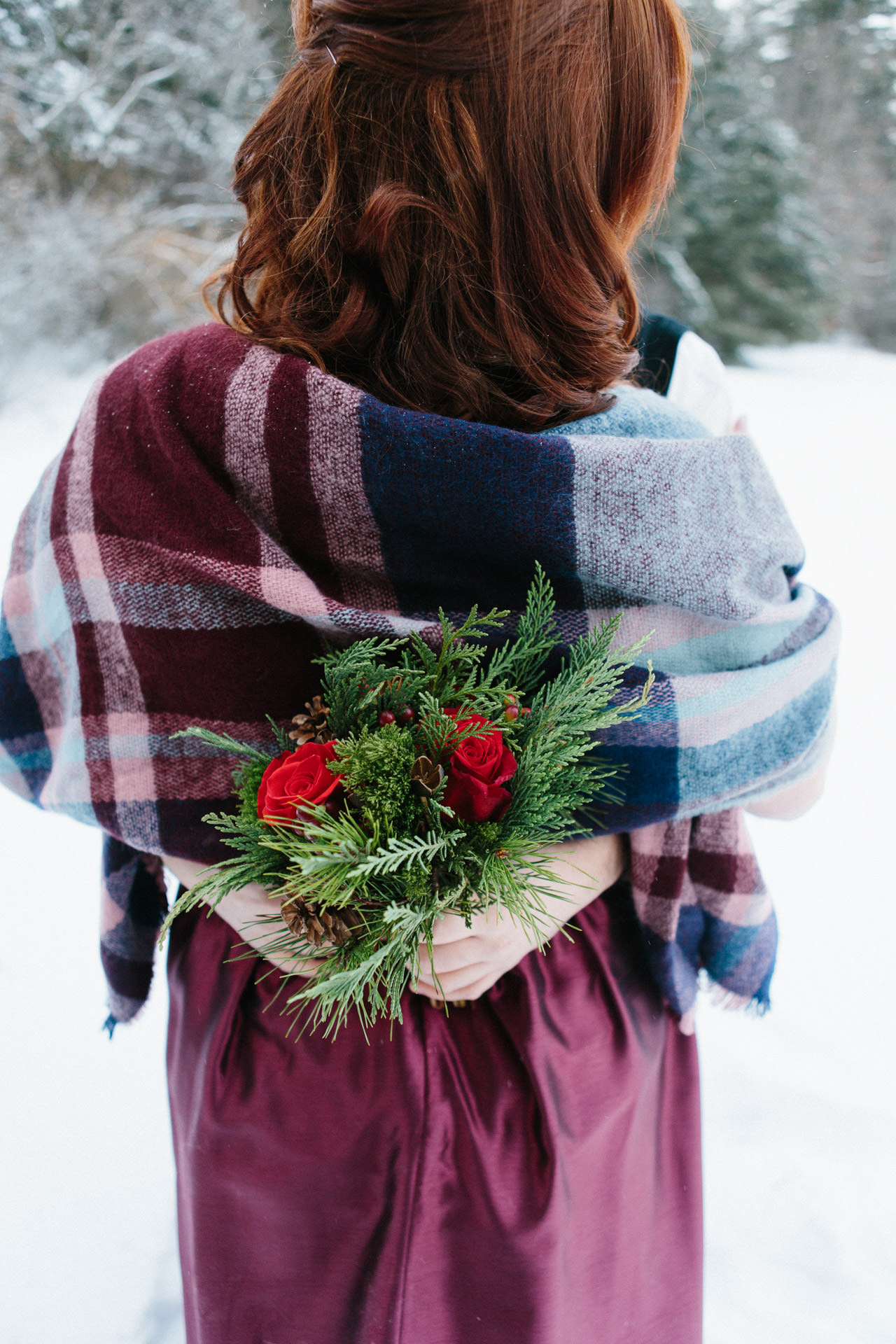 Winter wedding bouquet full of greens and red roses